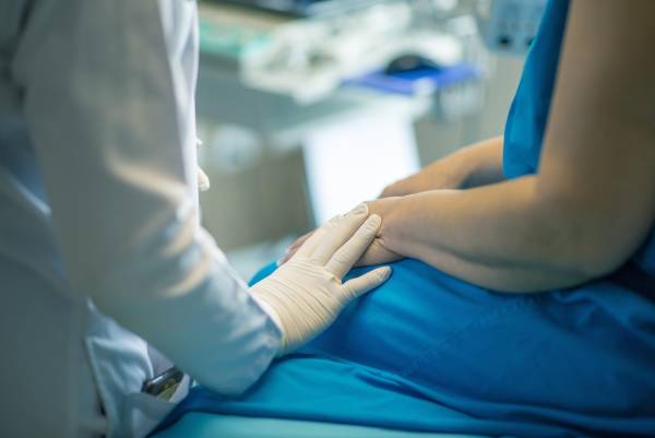 Patient som sitter hos en läkare på en privat klinik och får privatvård för sitt besvär.